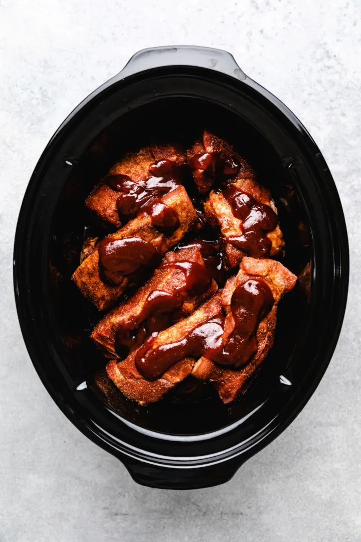 BBQ sauce on uncooked pork ribs.