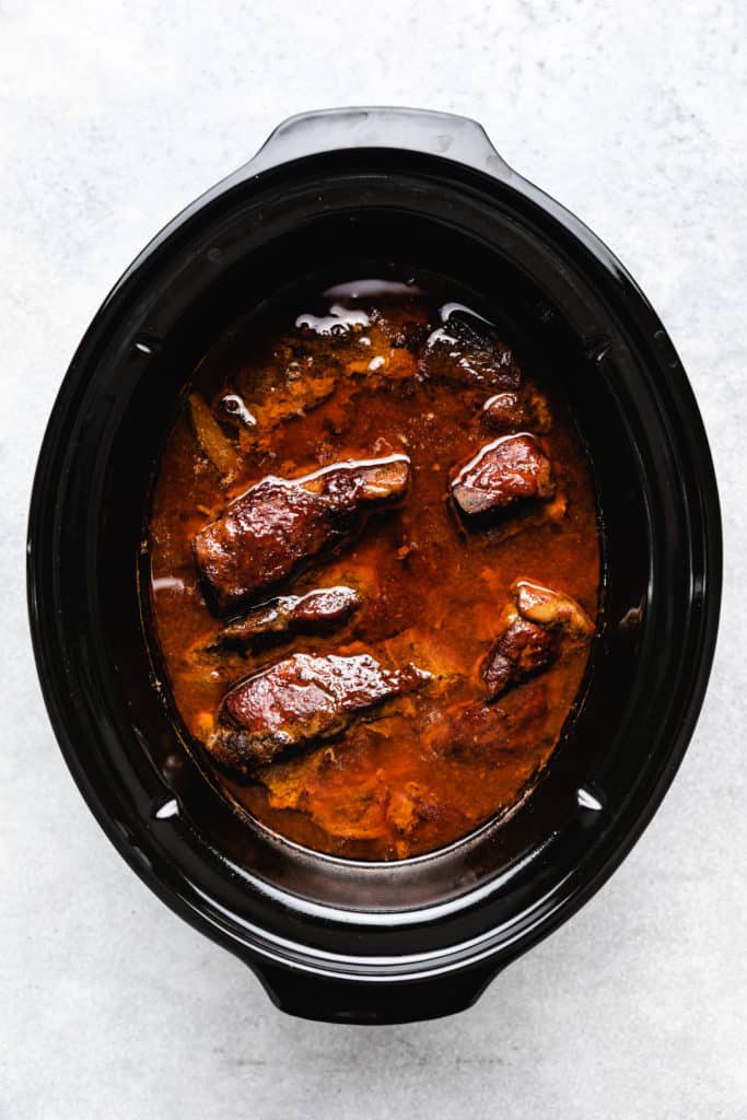 Crockpot filled with country style pork ribs.