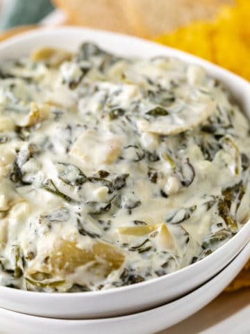 White bowl filled with spinach dip.