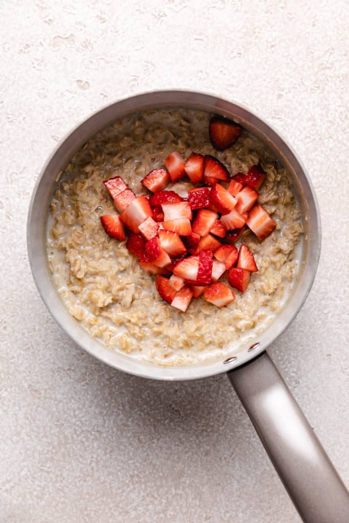 Strawberry pieces on top oatmeal in a pan.