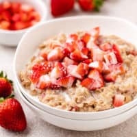 Close up view of diced strawberries on top of oatmeal.