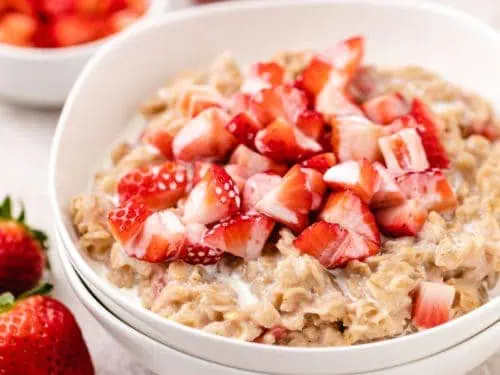 Close up view of diced strawberries on top of oatmeal.