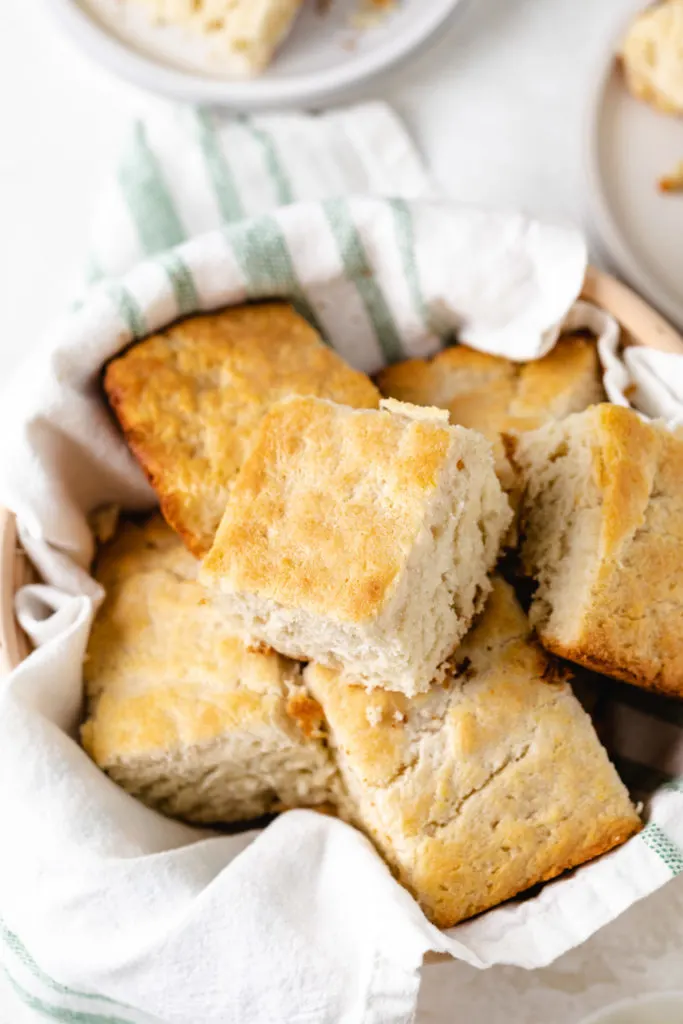 Square 7 up biscuits in a wooden basket.