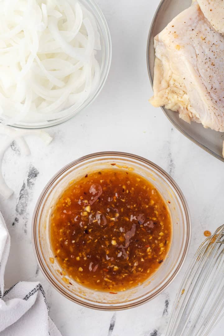 Apricot preserves, soy sauce, mustard, garlic, ginger and crushed red pepper flakes mixed in a bowl.