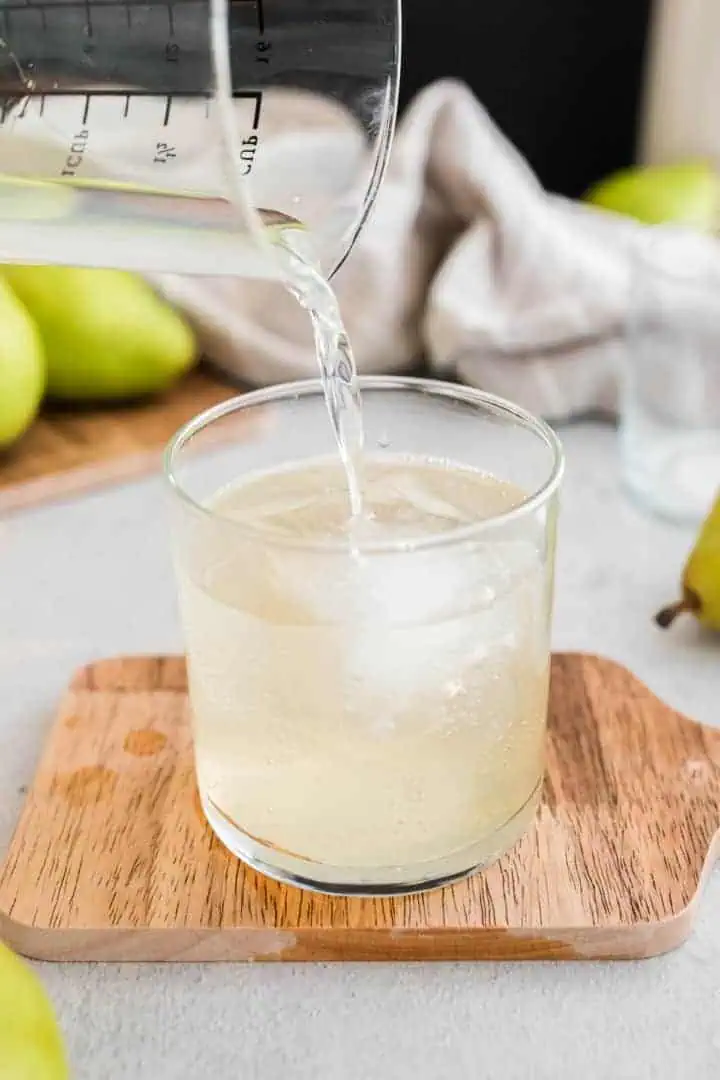 Vodka being poured into a cocktail.