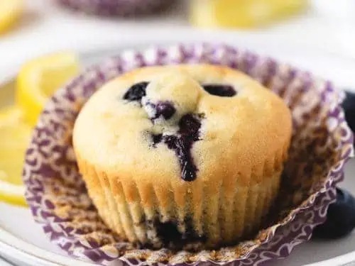 Close up view of a gluten free muffin on a paper liner.