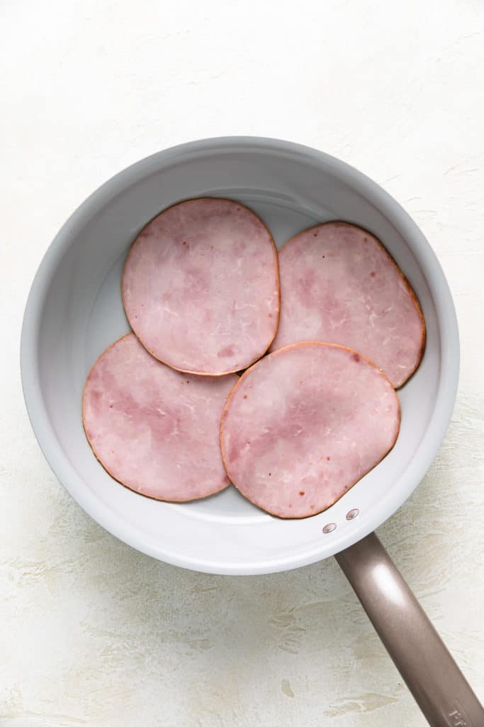 Ham slices in a pan.