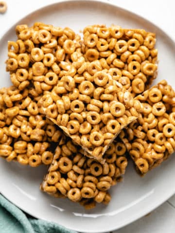 Close up view of a plate of peanut butter cheerio bars.