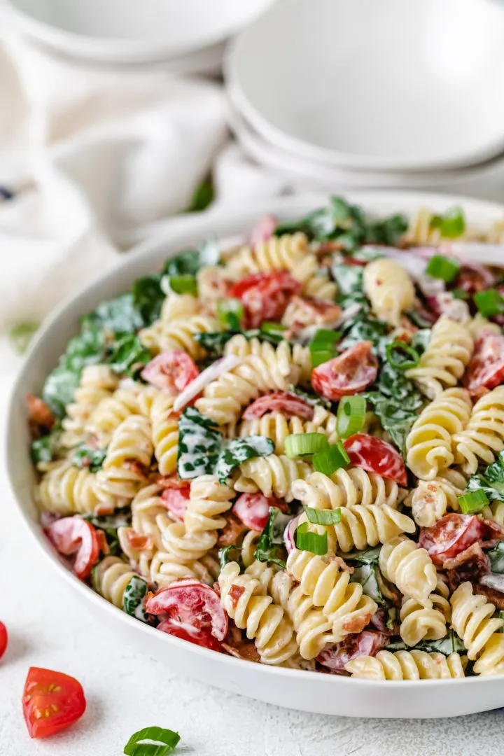 Creamy BLT pasta salad with crispy bacon, cherry tomatoes, and ranch dressing in a large bowl.