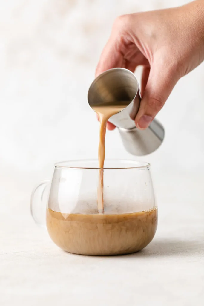 Jigger pouring Bailey's into coffee.