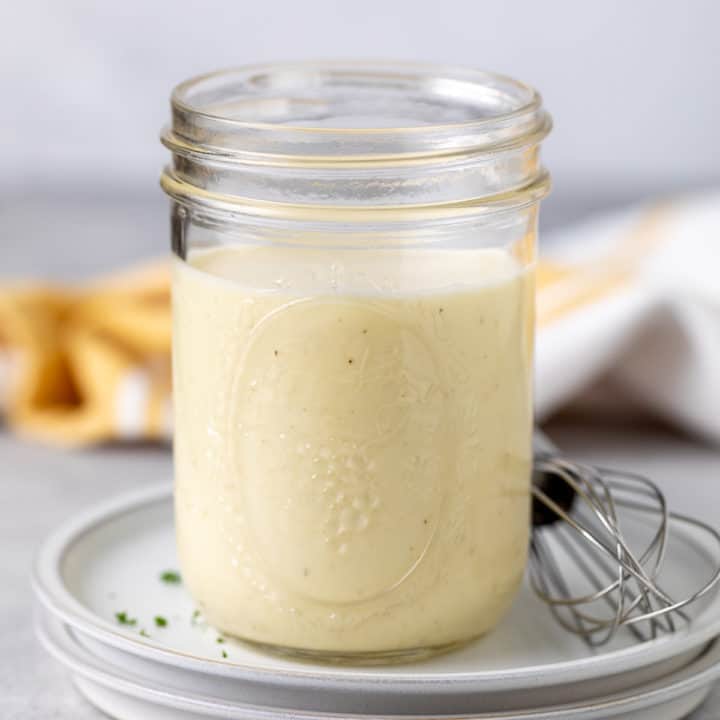 Jar of coleslaw dressing on a plate.