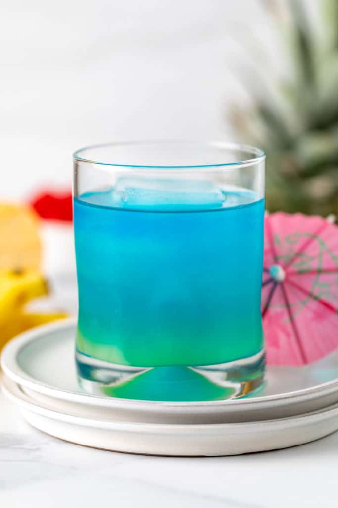 Blue curacao, pineapple juice, rum, and soda in a glass.