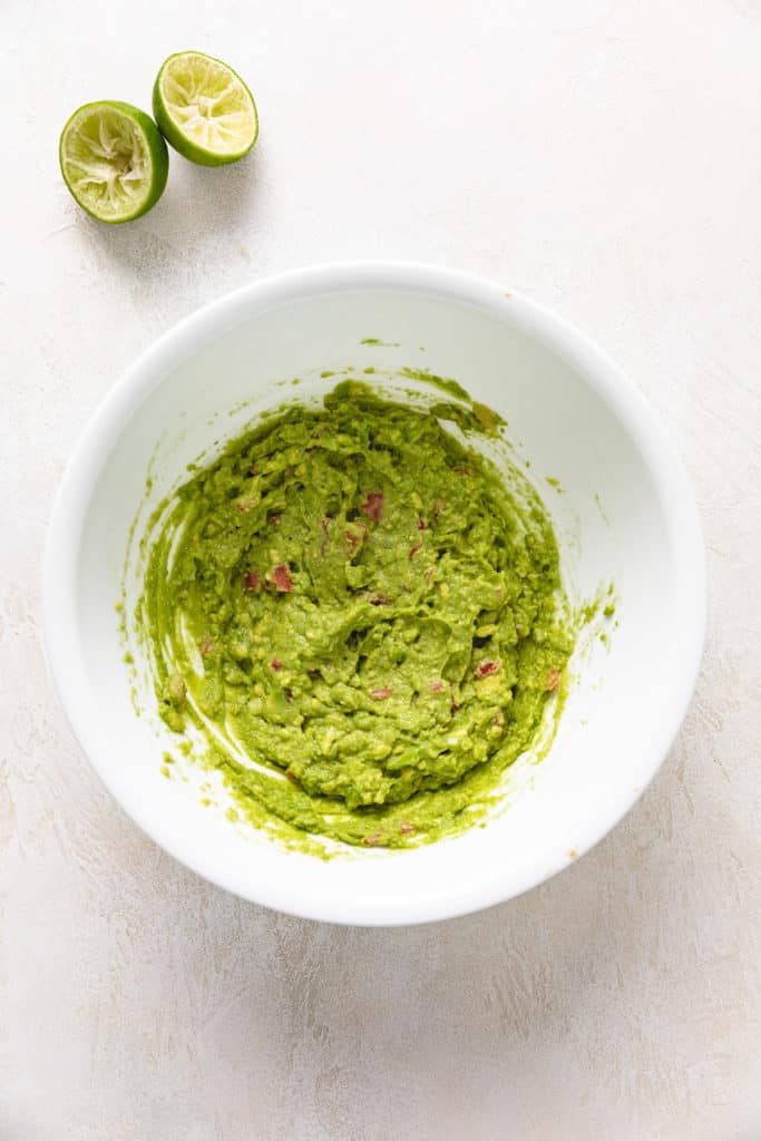 Fresh guacamole in a white bowl.