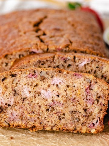 Close up view of a loaf of strawberry bread with nuts.