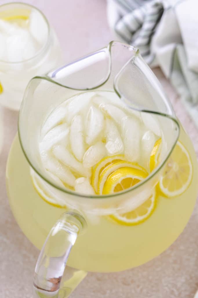 Pitcher of lemonade with ice and lemon wheels.