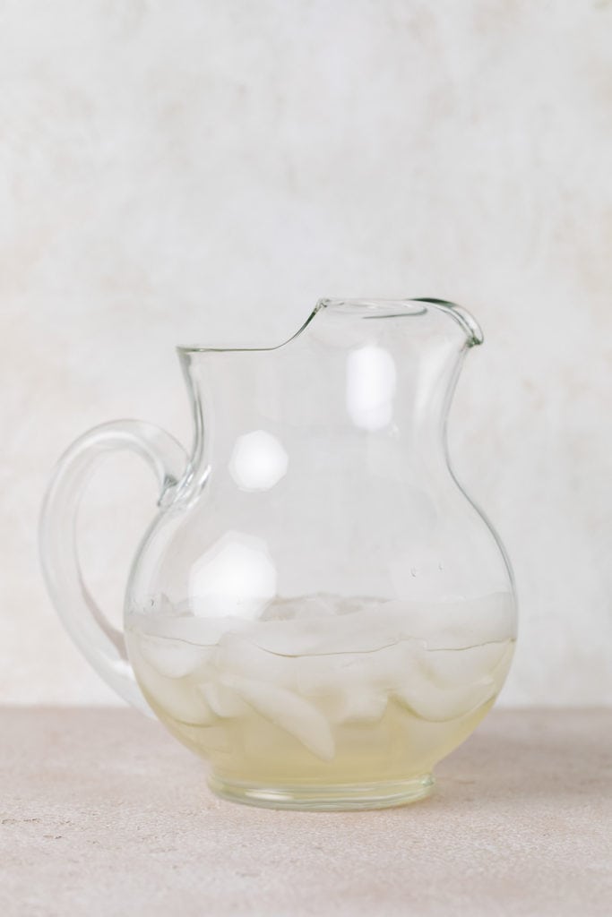 Simple syrup poured into a pitcher over ice.
