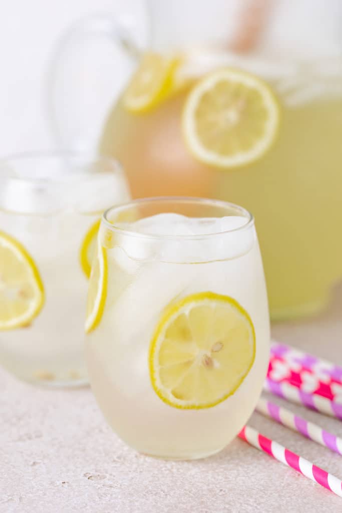 Colorful straws next to a glass of lemonade.
