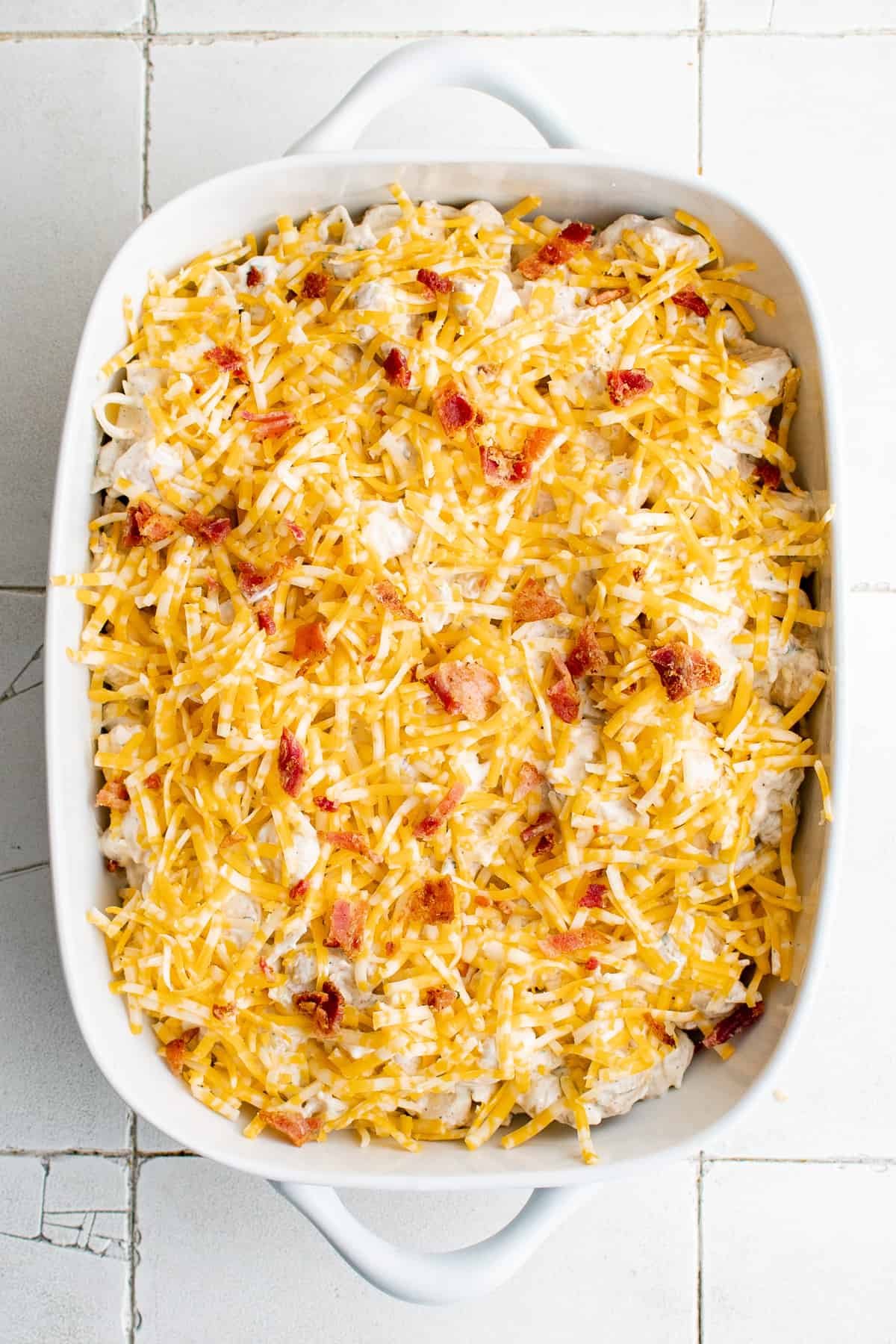 Bacon and cheese sprinkled over chicken casserole.