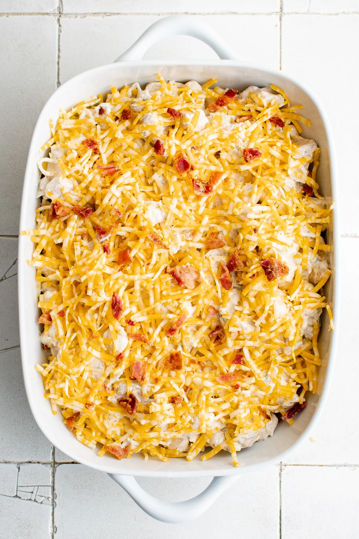 Bacon and cheese sprinkled over chicken casserole.