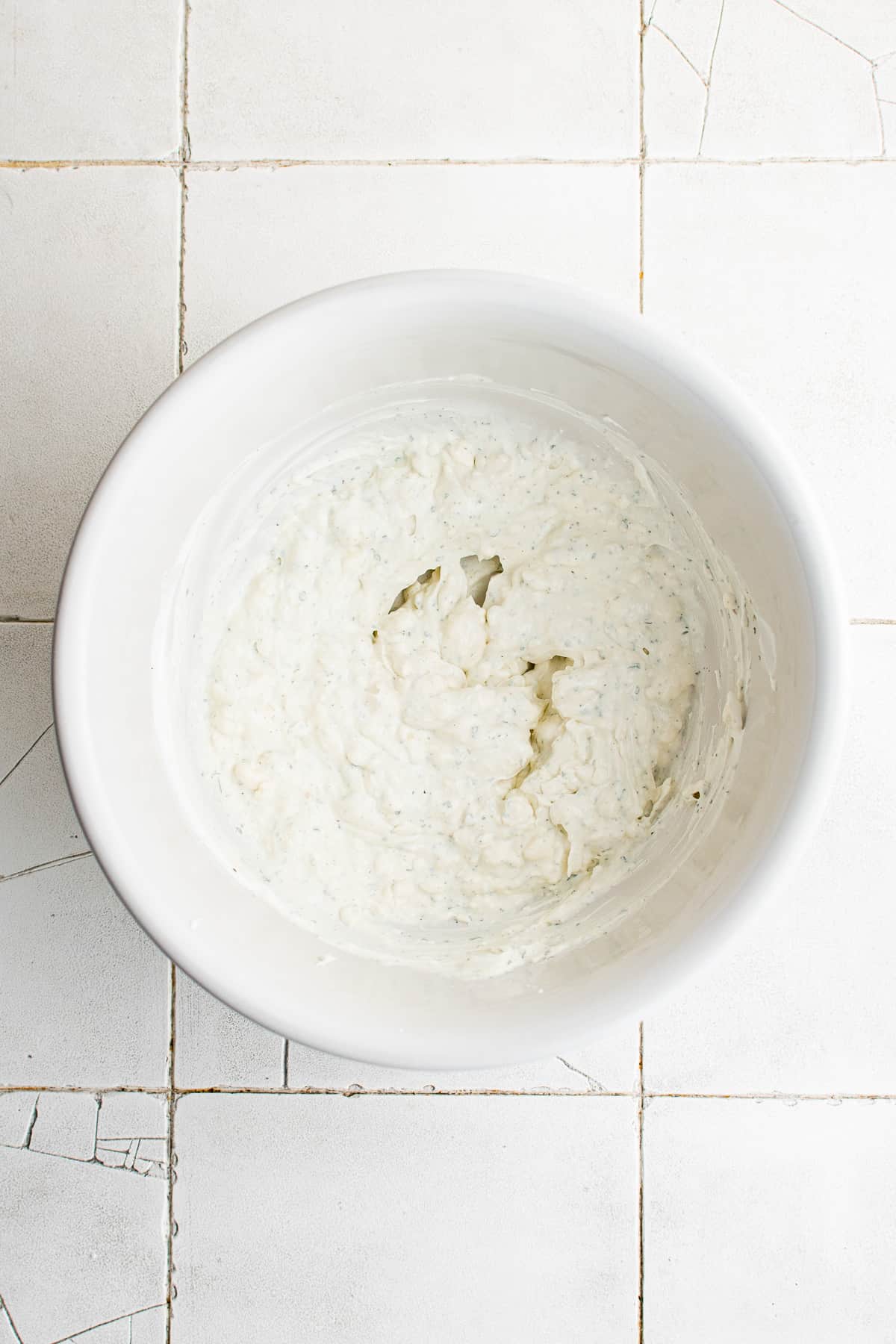 Cream cheese, sour cream and ranch seasoning mix stirred in a bowl.