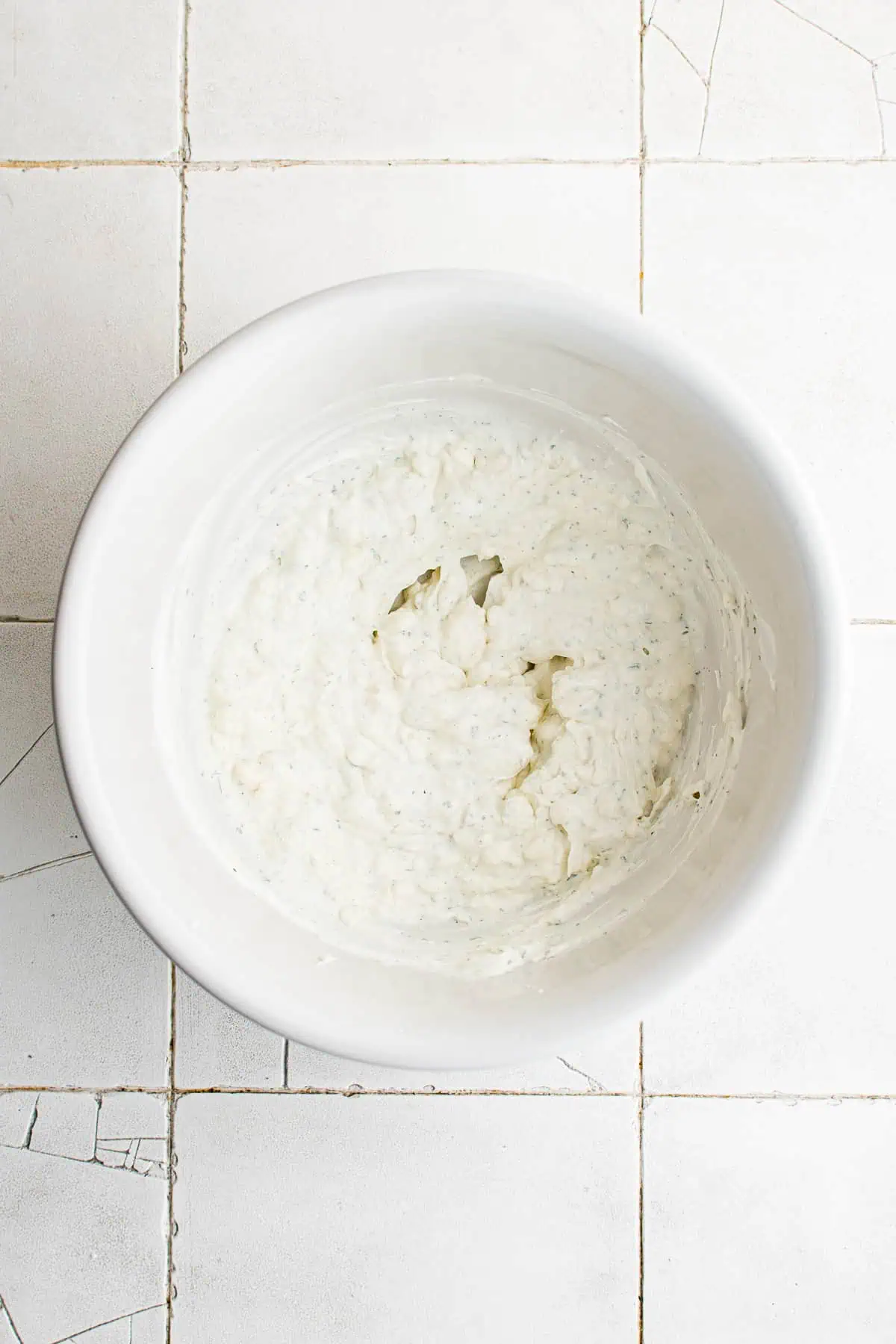 Cream cheese, sour cream and ranch seasoning mix stirred in a bowl.