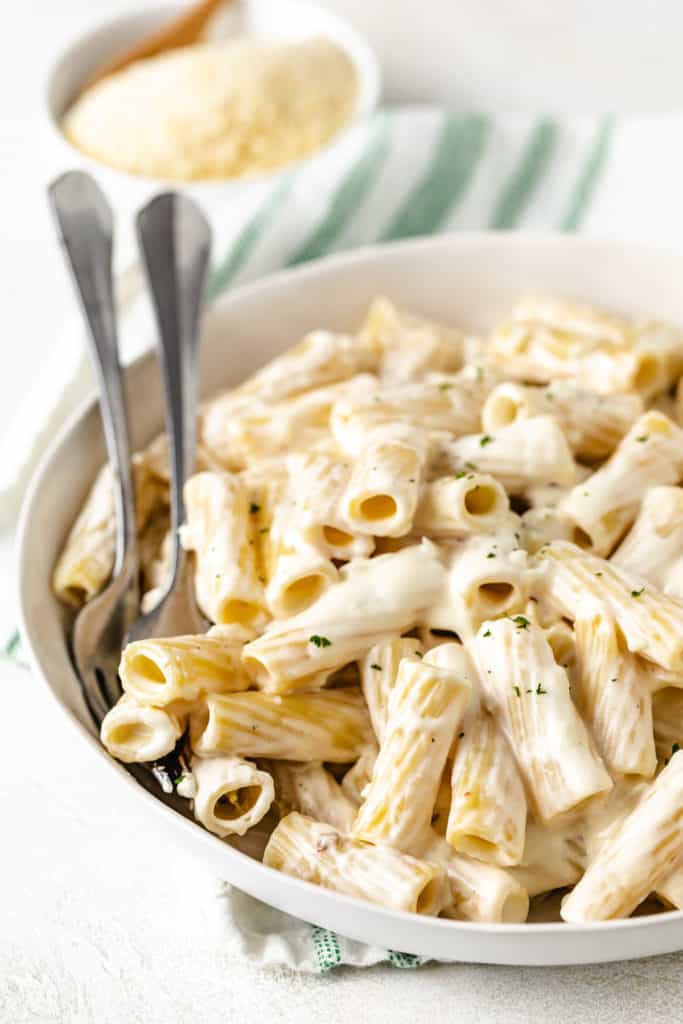 Two forks in a bowl of cream cheese pasta.