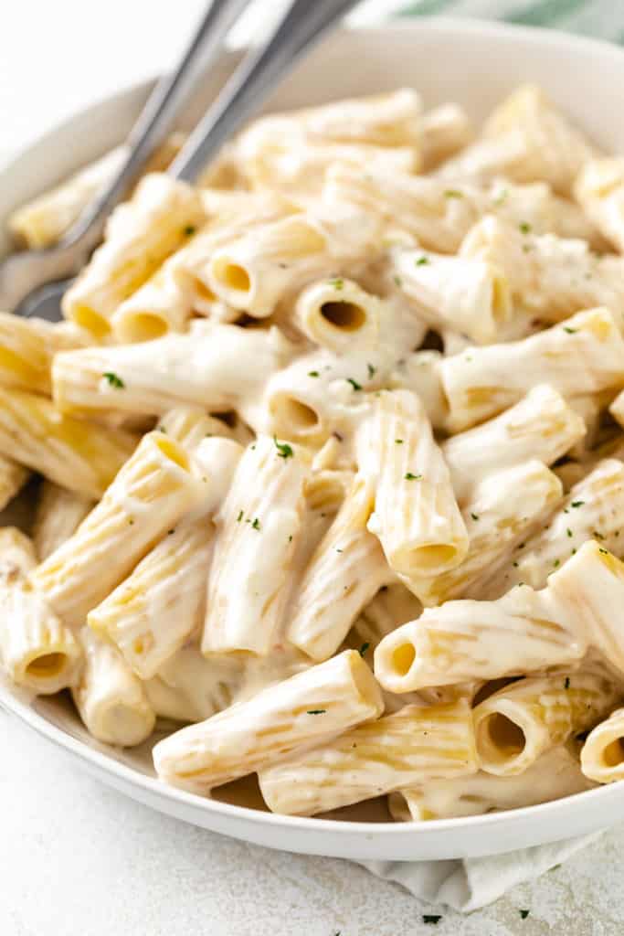 Close up view of creamy pasta in a serving dish.