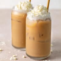 Close up view of two glasses of iced coffee with milk.