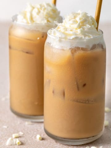 Close up view of two glasses of iced coffee with milk.