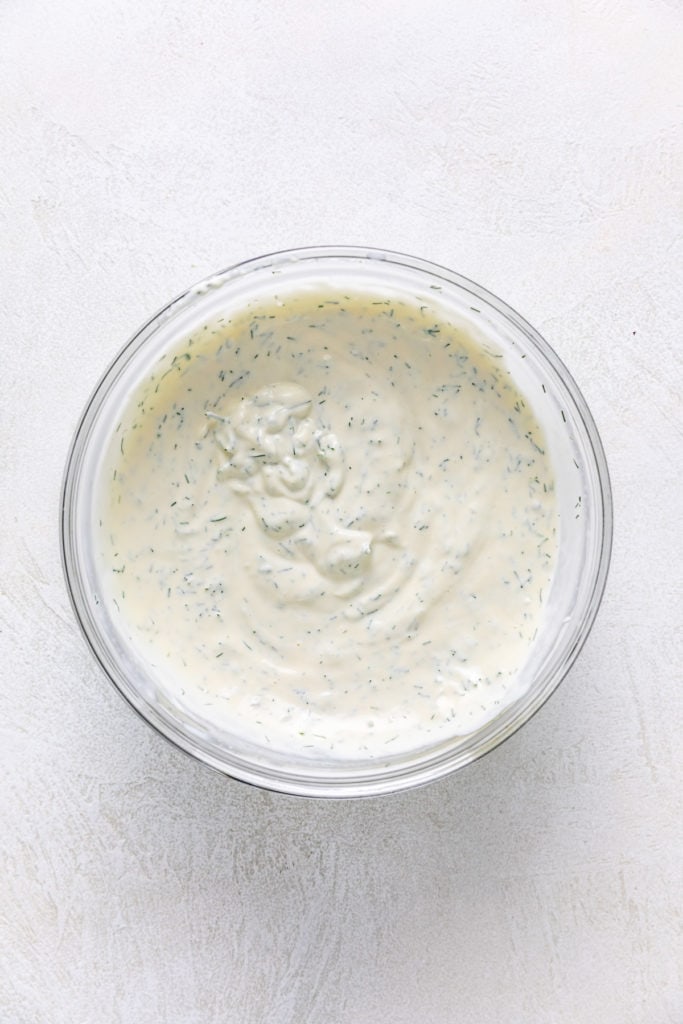 Lemon dill sauce in a glass mixing bowl.