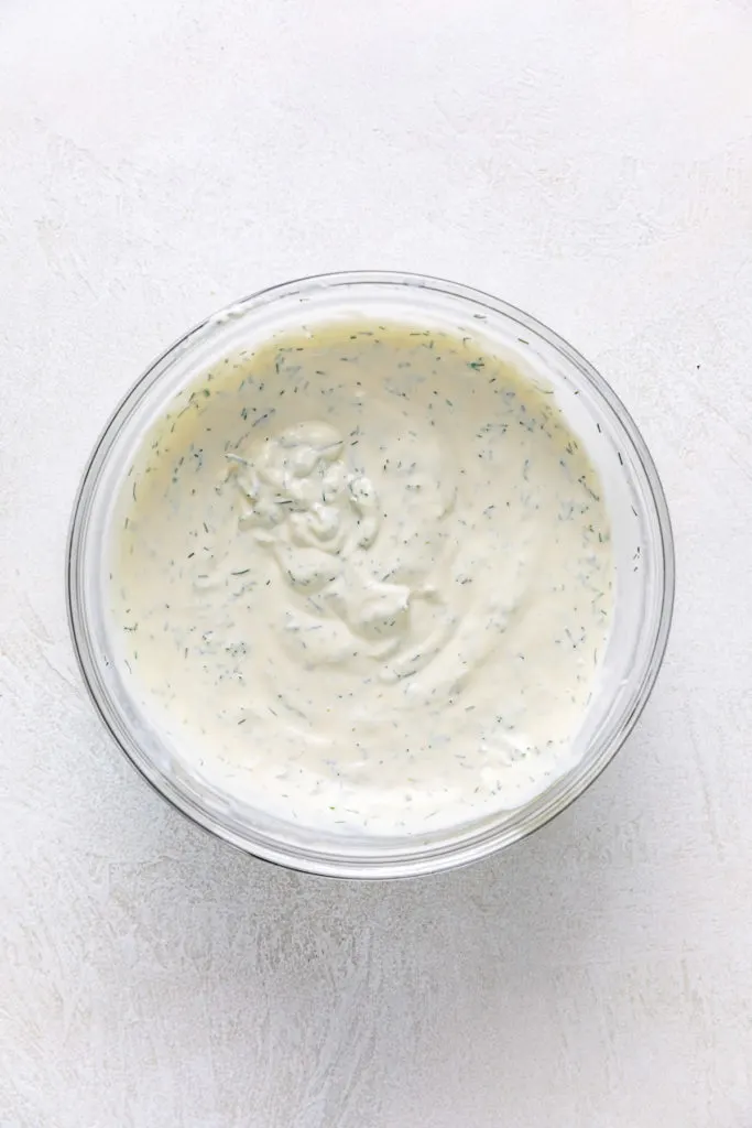 Lemon dill sauce in a glass mixing bowl.