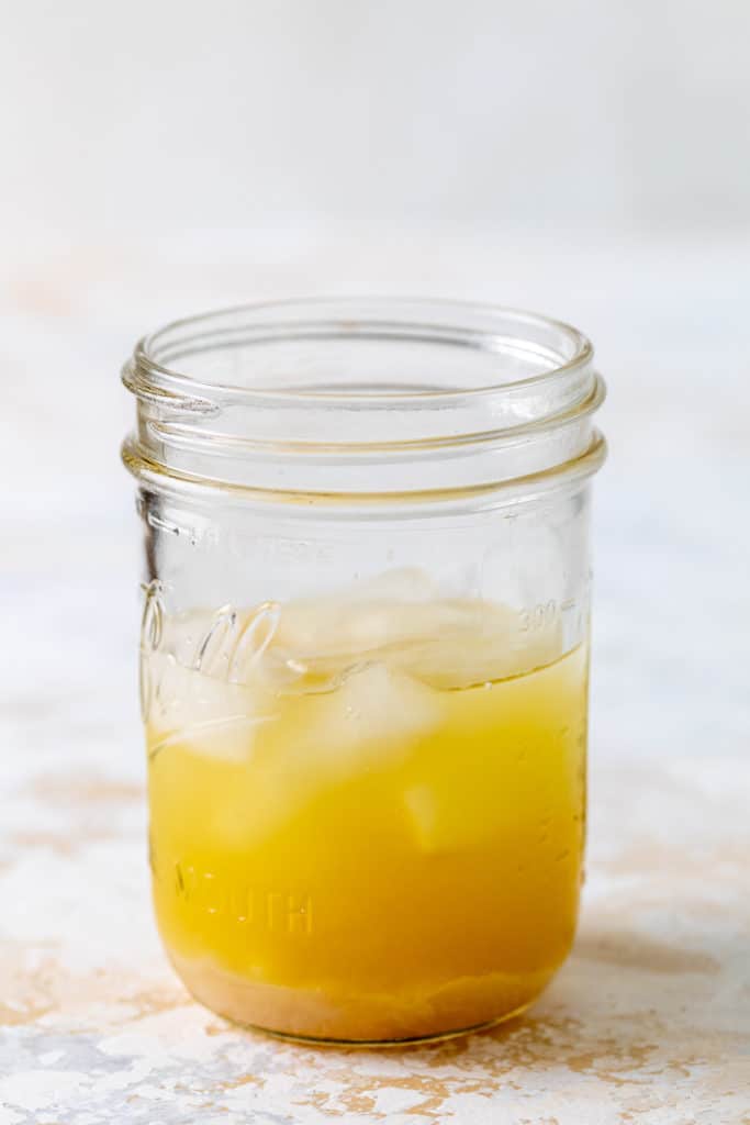 Ingredients for a pineapple and coconut cocktail in a jar.