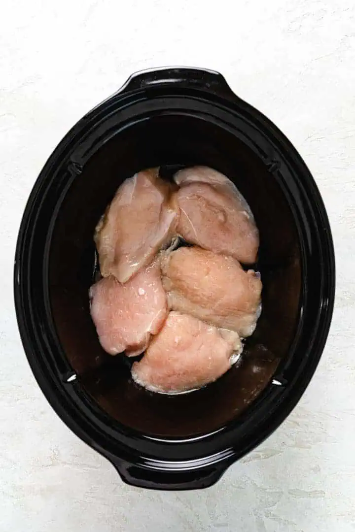 Slow Cooker Olive Garden Chicken Pasta Chicken breasts in a slow cooker.