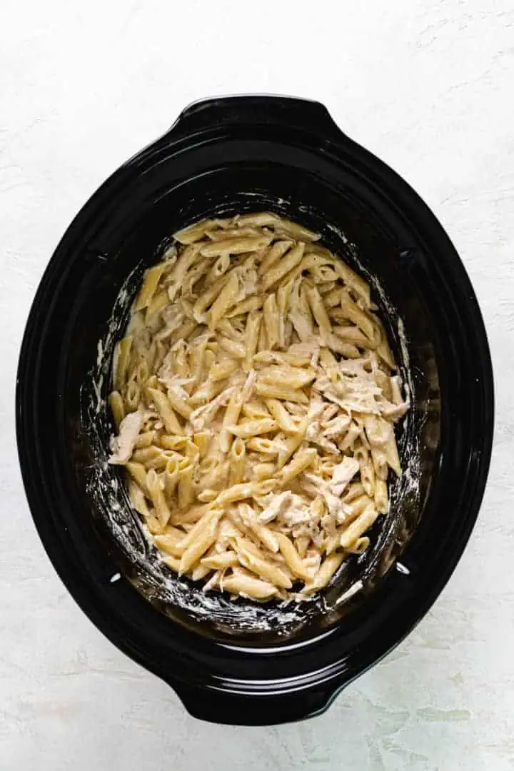Noodles stirred into the slow cooker with cream cheese, chicken, and Italian dressing.