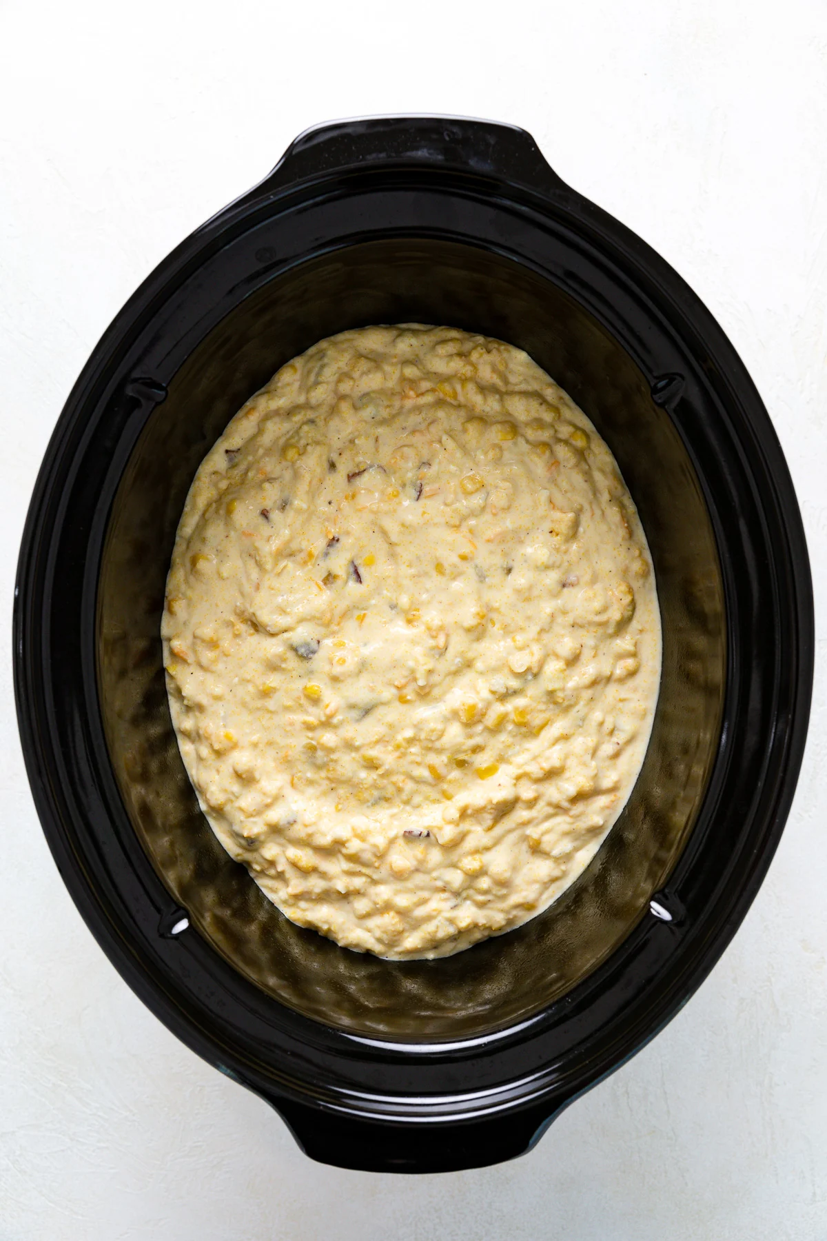 Corn casserole batter poured into a crock pot.