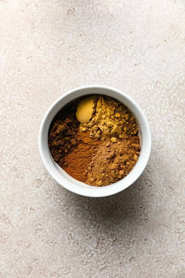 Cinnamon, nutmeg, cloves, and ginger in a bowl.