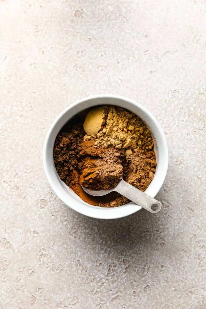 Cinnamon, nutmeg, ginger, allspice, and cloves in a bowl.