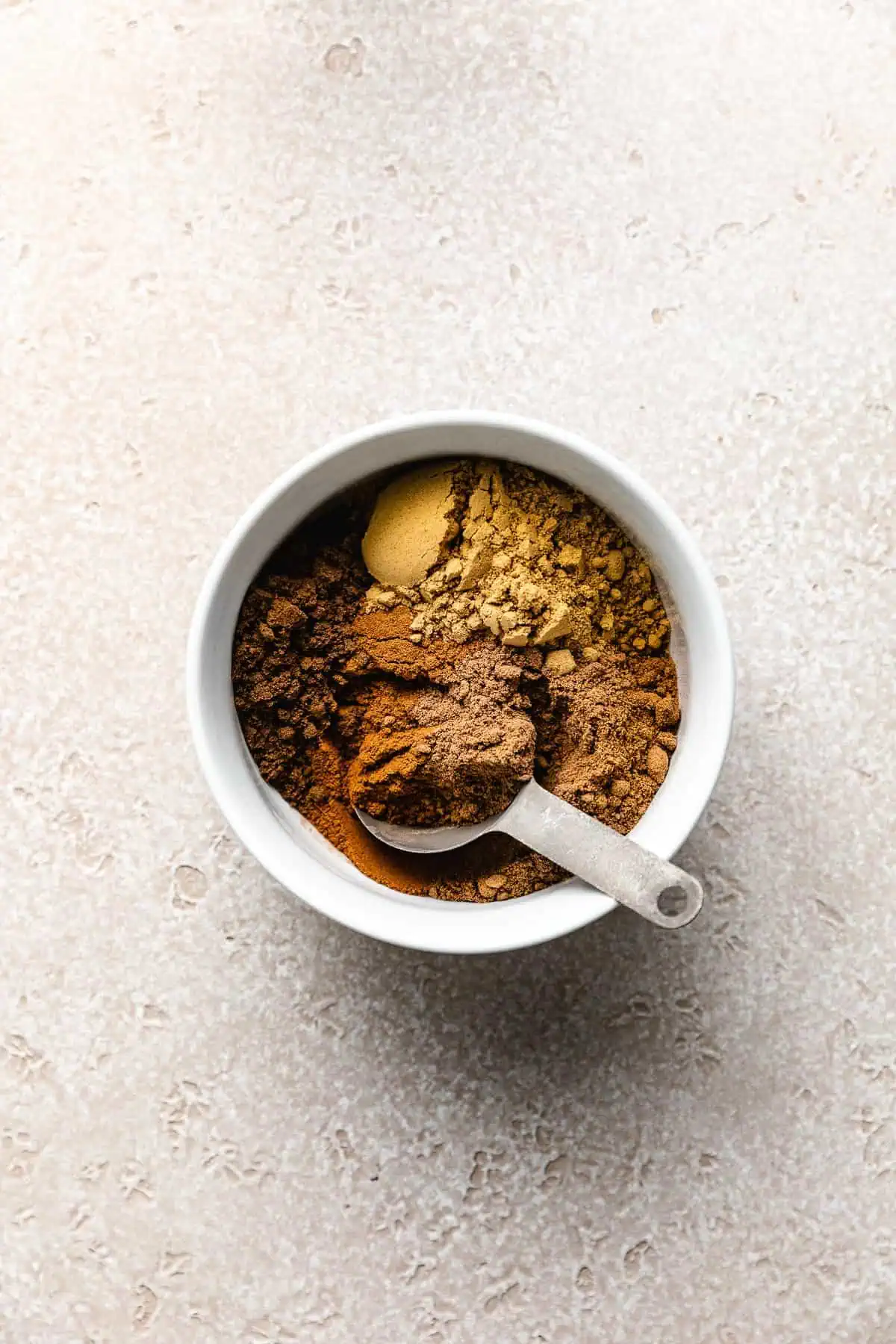 Cinnamon, nutmeg, ginger, allspice, and cloves in a bowl.