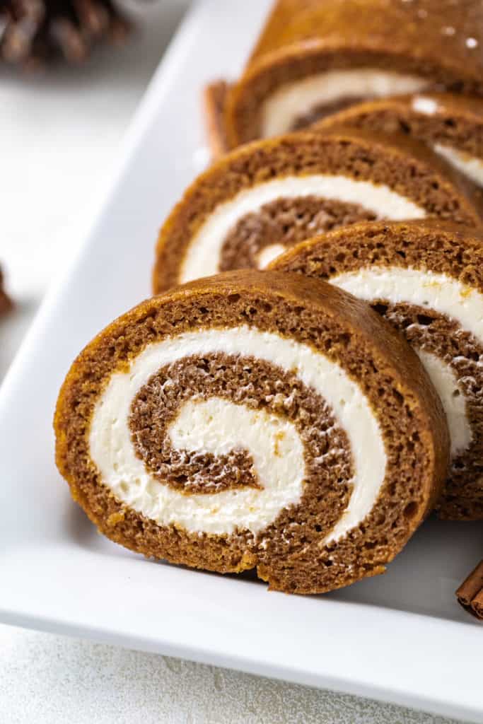 Pumpkin cake roll on a white platter.