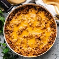 Cheesy hamburger rice casserole in a skillet.