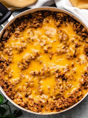 Cheesy hamburger rice casserole in a skillet.