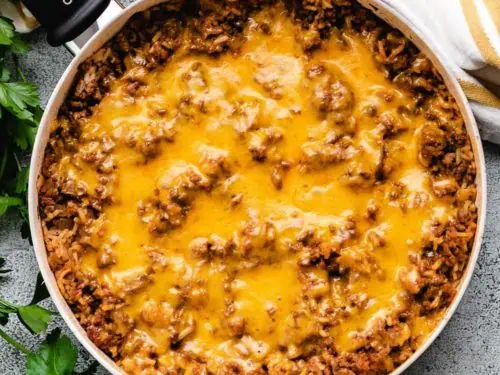 Cheesy hamburger rice casserole in a skillet.