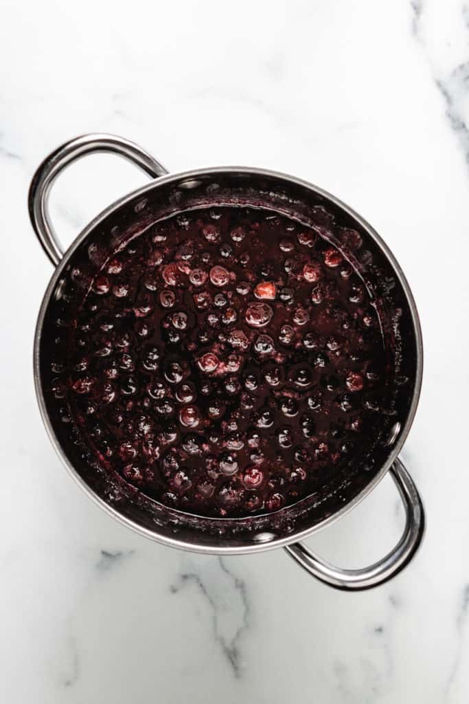 Cooked cranberries, sugar and water in a saucepan.