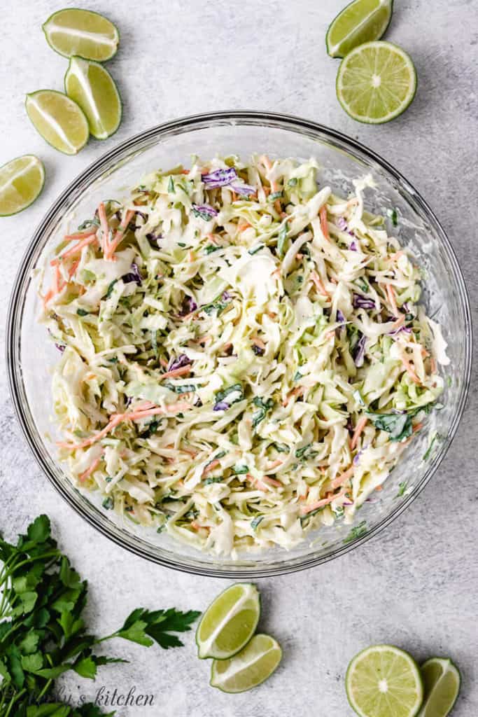 Creamy fish taco slaw in a glass mixing bowl.