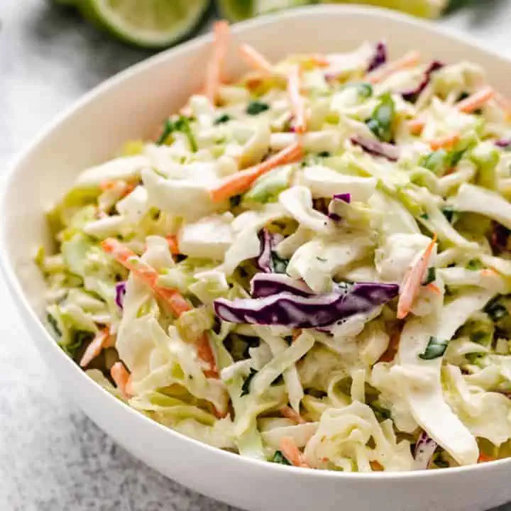 Close up view of a white bowl holding slaw.