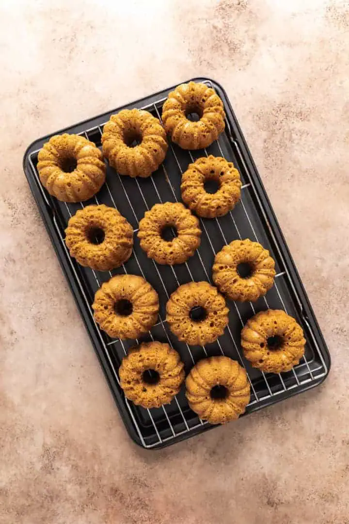 Mini pumpkin bundt cakes on a cooling rack.