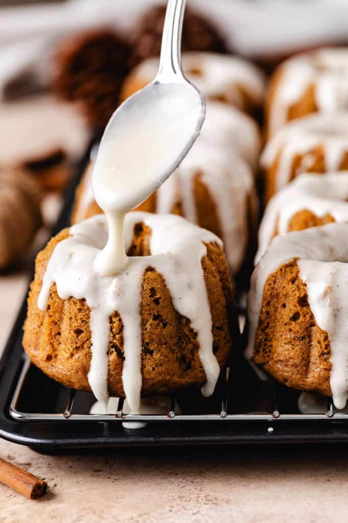 Maple glaze being drizzle over a cake.