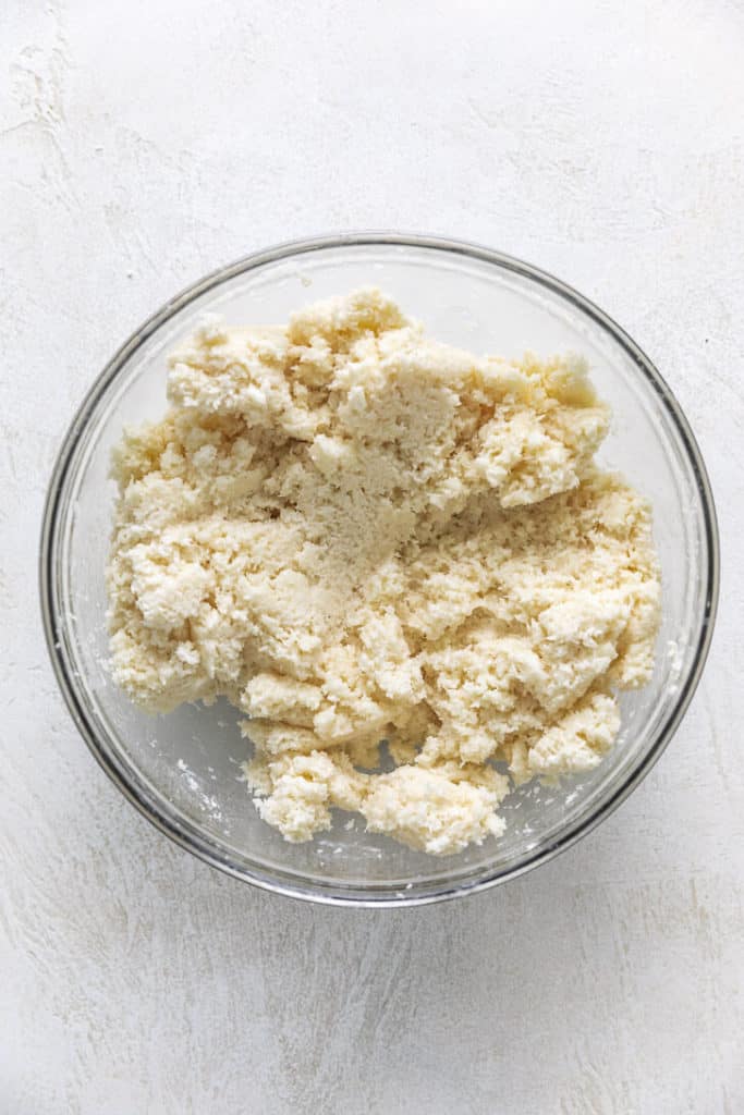 Shredded coconut, sweetened condensed milk, and powdered sugar stirred together in a bowl.