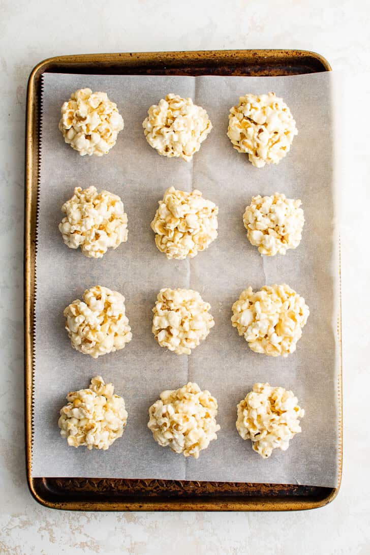 Formed popcorn candy treats on a baking pan.
