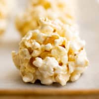 Close up view of a popcorn ball on parchment paper.